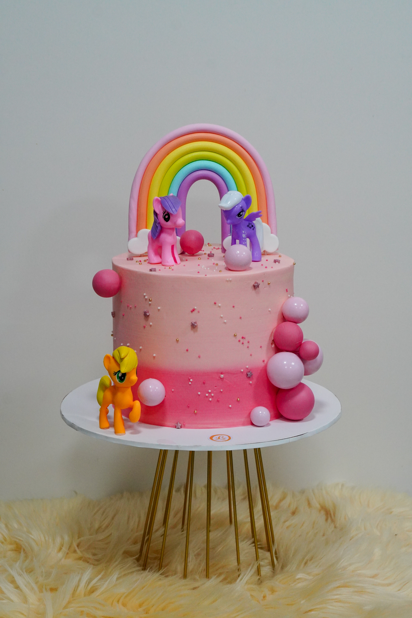 Pink ombre My Little Pony birthday cake with rainbow topper and balloon decorations
